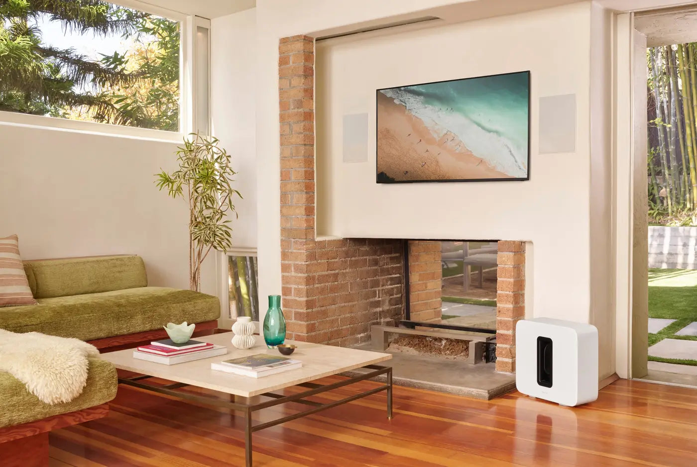 A Sonos system in a bright living room with a brick fireplace